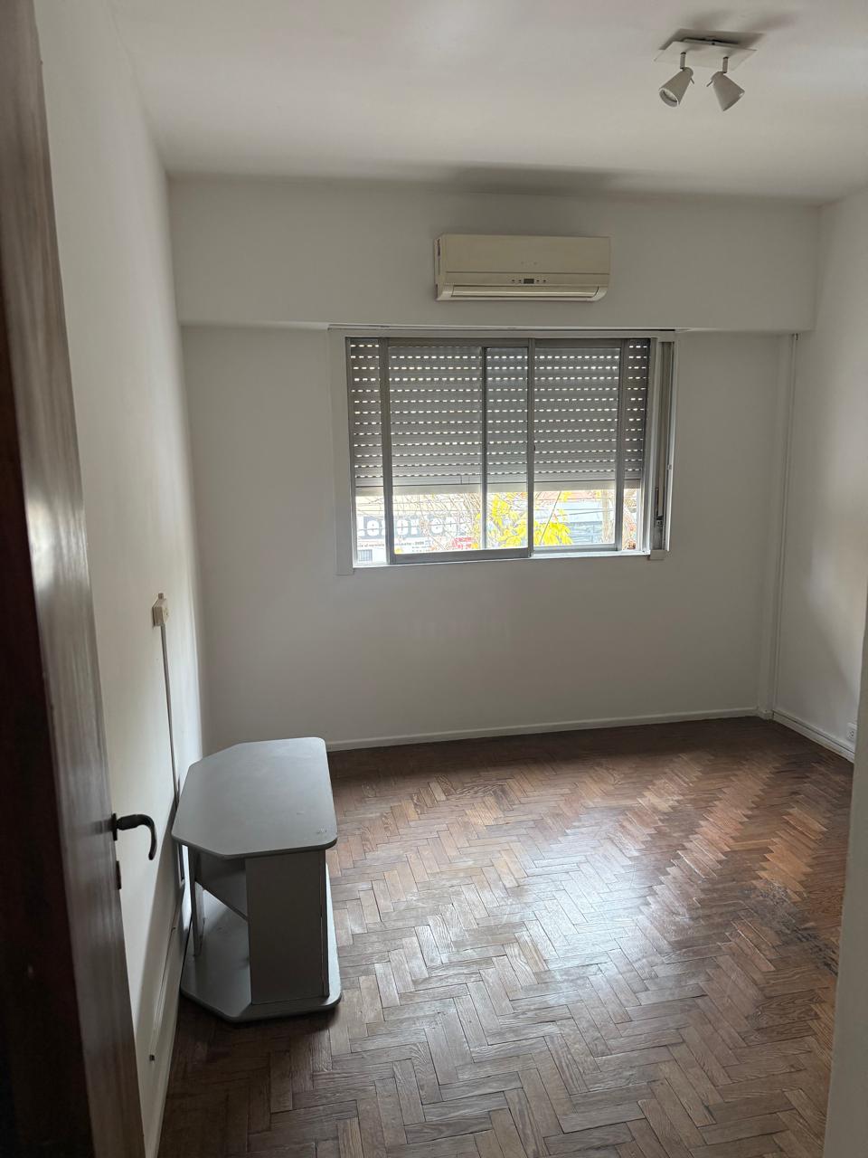 Dormitorio con piso de parquet